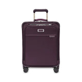 Briggs & Riley Baseline Global Carry-On Spinner luggage with blue hard-shell exterior and four spinner wheels.