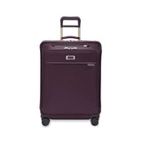 Briggs & Riley Baseline medium expandable spinner suitcase with blue hard shell, four wheels, and telescopic handle for travel.