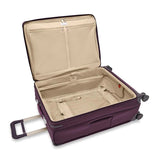 Briggs & Riley Baseline large expandable checked luggage spinner with blue hard shell exterior and four wheels for easy travel.