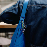 Peak Design City Crescent 6L compact travel bag shown in a lifestyle setting with adjustable strap and minimalist design.