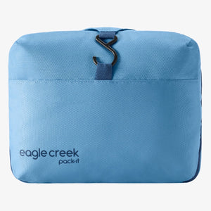 Eagle Creek PACK-IT™ Hanging Toiletry Kit open with compartments and toiletries inside, hanging on a hook for travel organization