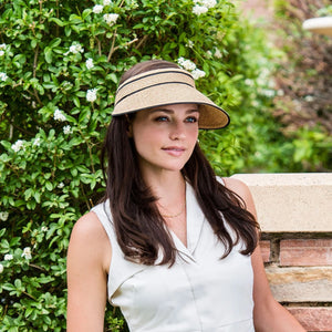 Wallaroo Hat Company Lily packable visor hat in beige and black, shown worn outdoors for sun protection and style.