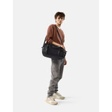 Black Matador 30L packable duffel bag shown folded and partially unfolded, lightweight and compact travel gear.