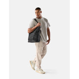 Black Matador 24L Tote Pack with adjustable straps and durable fabric, designed for versatile carrying and outdoor use.