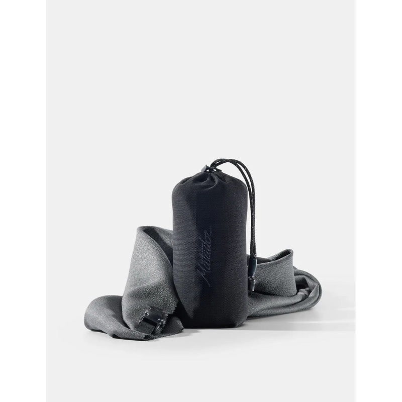 Large Matador ultralight travel towel displayed folded and spread out, showing its compact, quick-drying fabric in a neutral color.