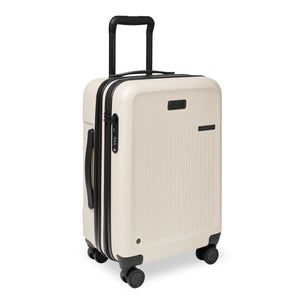 Briggs & Riley Sympatico essential carry-on expandable spinner suitcase in ivory, showing angled view with wheels and handle.