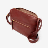 Osgoode Marley Zella small crossbody bag in Brandy, shown from side view with adjustable strap and compact design.