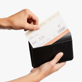Black Bellroy passport cover with sleek leather design and multiple card slots, designed to protect and organize your travel documents.