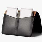 Black Bellroy passport cover with sleek leather design, featuring multiple card slots and a secure closure.