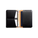Black Bellroy passport cover with multiple card slots and sleek design, crafted from premium leather.