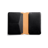 Black Bellroy passport cover with sleek leather design and multiple card slots, designed to protect and organize your passport.