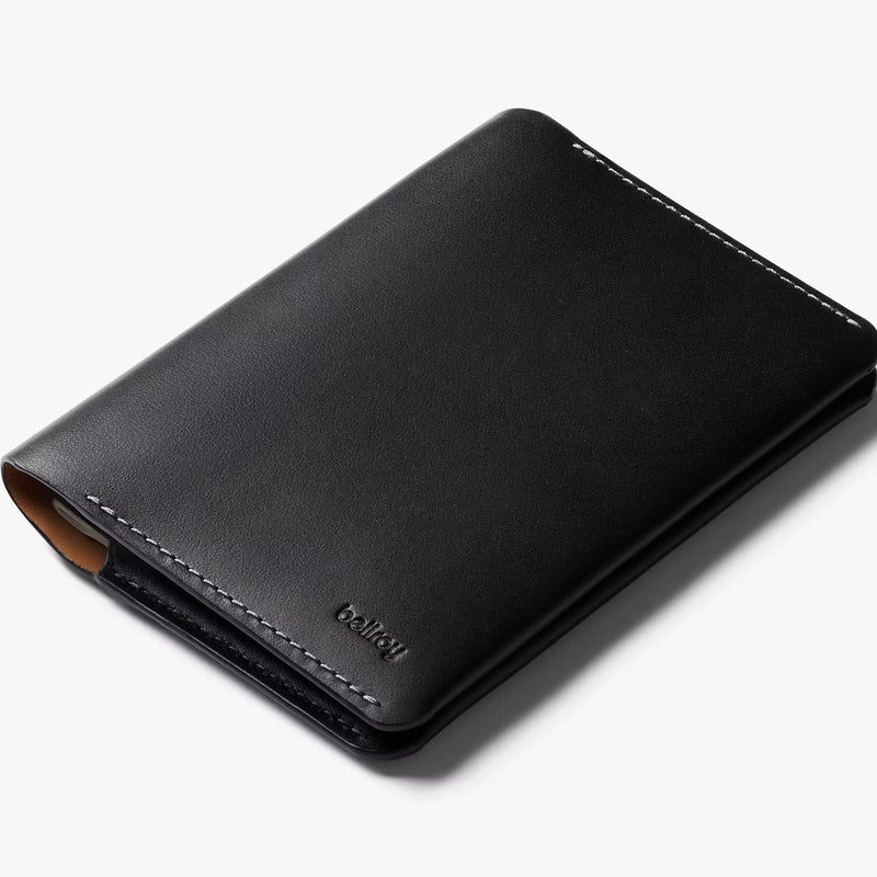 Black Bellroy passport cover with sleek design and multiple card slots, made from premium leather.