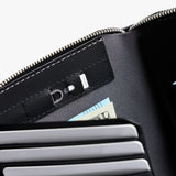 Bellroy Travel Folio 2nd Edition open with organized slots for passport, cards, and travel documents on sleek leather surface.