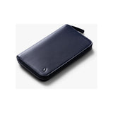 Bellroy Travel Folio 2nd Edition open with passport, boarding passes, and cards inside, showcasing sleek leather travel organizer.