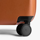 Bellroy Transit Carry-On Large luggage in chalk color, showing its sleek design and sturdy handle for travel convenience.