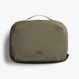 Bellroy Hanging Toiletry Kit Plus in stone color, showing compact toiletry bag with hanging hook and multiple compartments.