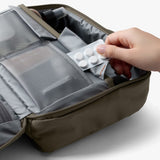 Bellroy Hanging Toiletry Kit Plus in stone color showing multiple compartments and hanging hook for organized travel toiletry storage.