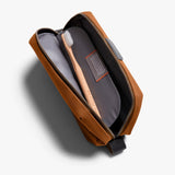 Bellroy toiletry kit in clay color, compact travel bag with multiple compartments for grooming essentials.