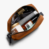 Bellroy toiletry kit in clay color with multiple compartments and zipper closure, designed for organizing personal grooming essentials.