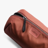 Bellroy Toiletry Kit Plus in clay, a compact travel toiletry bag with multiple compartments for toiletries and grooming essentials.