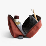 Bellroy Toiletry Kit Plus in clay with multiple compartments and zipper closure, designed for organized travel toiletry storage.