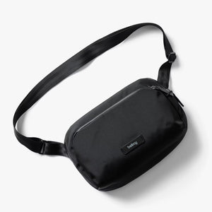 Bellroy Transit Sling 5L waist pack in black showing compact design with adjustable strap and multiple zipper compartments.