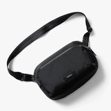 Bellroy Transit Sling 5L waist pack in black showing compact design with adjustable strap and multiple zipper compartments.