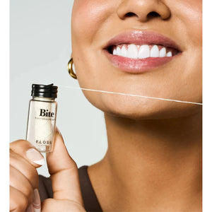 Bite Floss, dental floss product with a sleek design, showing the floss string and packaging in a clean, close-up shot.