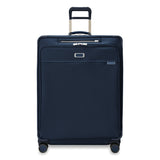 Briggs & Riley Baseline extra large expandable checked luggage spinner in blue with four wheels and telescoping handle.