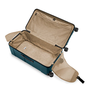 Interior view of Briggs & Riley Torq extra large checked luggage trunk with organized compartments and durable design.
