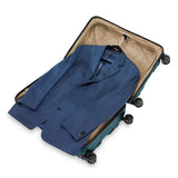 Briggs & Riley Torq medium spinner suitcase in stealth black with four wheels and a sturdy handle, designed for travel durability.