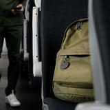 Chipolo ONE Spot Bluetooth tracker attached to a backpack, showing its keyring and compact design for Apple device tracking.