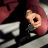 Chipolo ONE Spot key finder device for Apple, showing the small round tracker with Chipolo branding and keyring attachment.