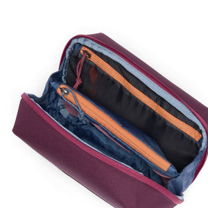 Cotopaxi Viaje Tech Organizer in black with multiple compartments for cables, chargers, and tech accessories on a white background.
