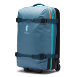 Cotopaxi 65L roller checked luggage bag with durable hard shell and telescoping handle, suitable for travel.