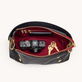 Hammitt Bryant Med crossbody bag in black brushed gold with red zipper, featuring sleek design and adjustable strap.