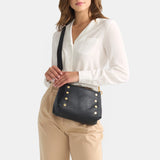 Hammitt Bryant Med crossbody bag in black brushed gold with red zipper, featuring compact design and adjustable strap.
