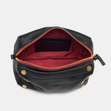 Black Hammitt Evan crossbody bag with brushed gold hardware and red zipper, compact design for everyday style.
