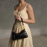 Black Hammitt Kyle Med handbag with brushed gold hardware and red zipper, stylish leather shoulder bag for women.