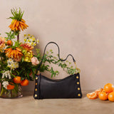 Black Hammitt Kyle Med handbag with brushed gold accents and red zipper, featuring a sleek, stylish design.