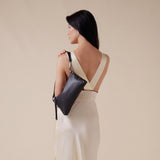 Black Hammitt Kyle Med handbag with brushed gold accents and red zipper, featuring a sleek, stylish design and top handle.