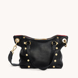 Black Hammitt Daniel Med purse with brushed gold accents and red zipper, showcasing a sleek, stylish design.