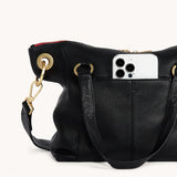 Black Hammitt Daniel Med purse with brushed gold hardware and red zipper, featuring a sleek, stylish design.