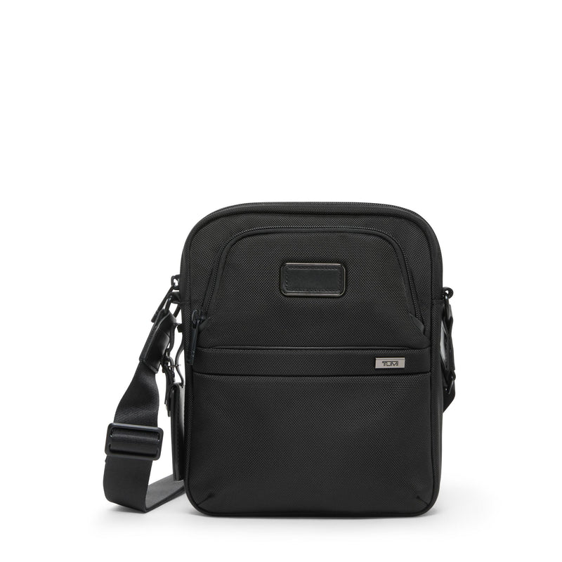 Tumi Alpha medium crossbody bag with adjustable strap and multiple compartments, shown in a sleek urban style.