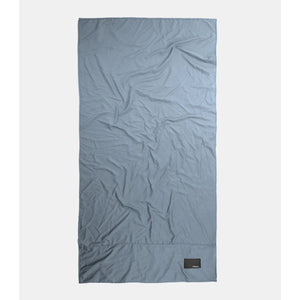 Charcoal Matador Nanodry packable beach towel folded with textured fabric, compact and lightweight for travel and outdoor use.