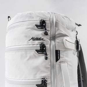Matador SEG28 backpack in arctic white, featuring a sleek, compact design with multiple compartments and adjustable straps.