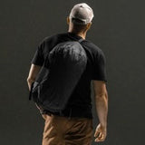 Matador Freefly 30L packable duffle bag in black, made of durable fabric, shown folded and unfolded for travel storage.