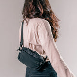 Matador ReFraction™ packable waist sling with adjustable strap and compact design, shown in a studio setting.