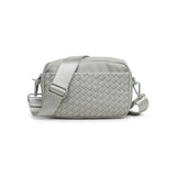 Sol & Selene woven neoprene crossbody bag with adjustable strap and minimalist design, shown in natural light highlighting texture.