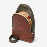 Osgoode Marley Cyrus sling bag in moss green, showing side view with adjustable strap and stylish leather details.